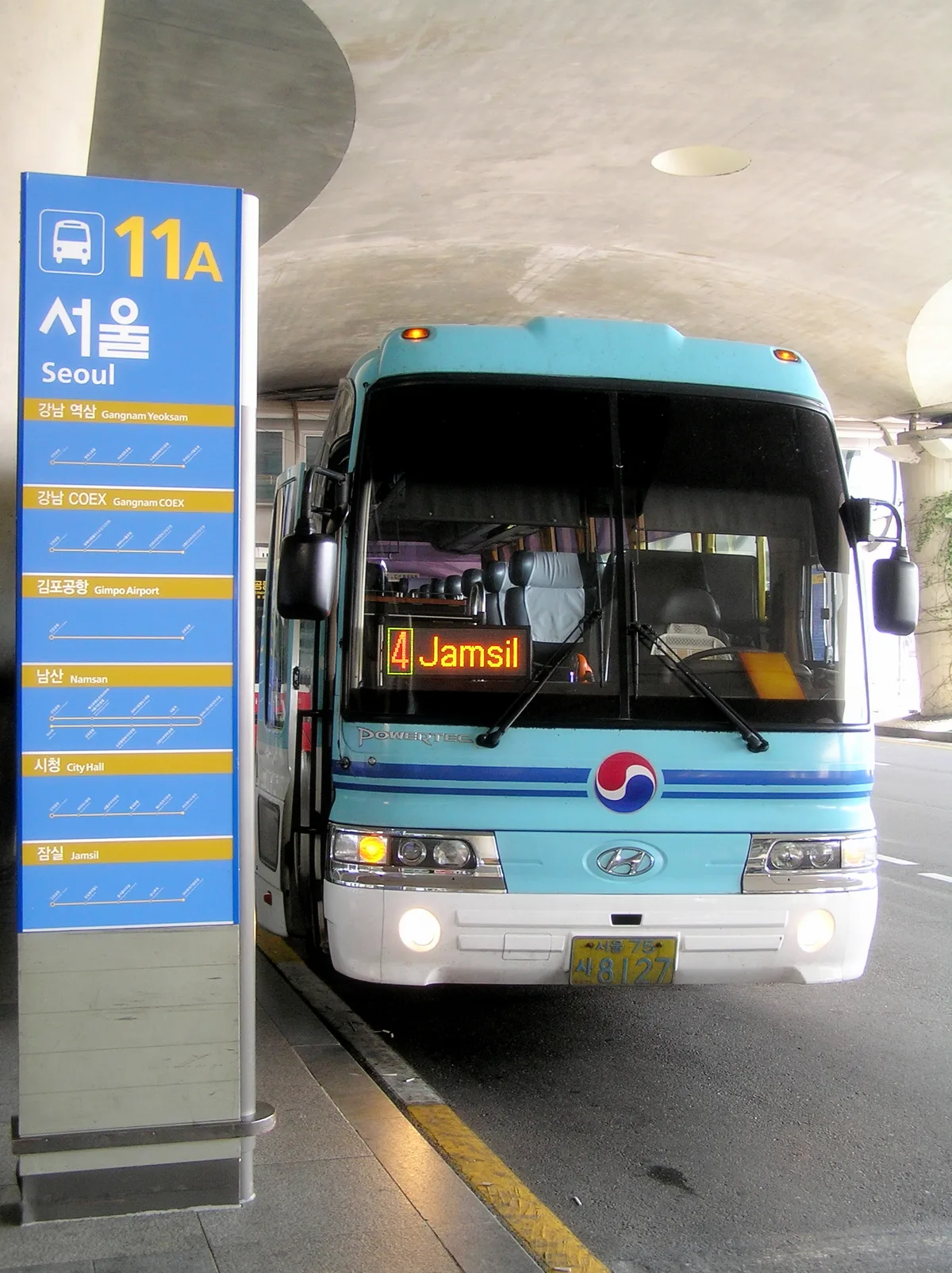 An airport limousine bus bound for Seoul (route 11A) boarding at Incheon International Airport, with a route sign listing Gangnam, Namsan, City Hall, and Jamsil stops.