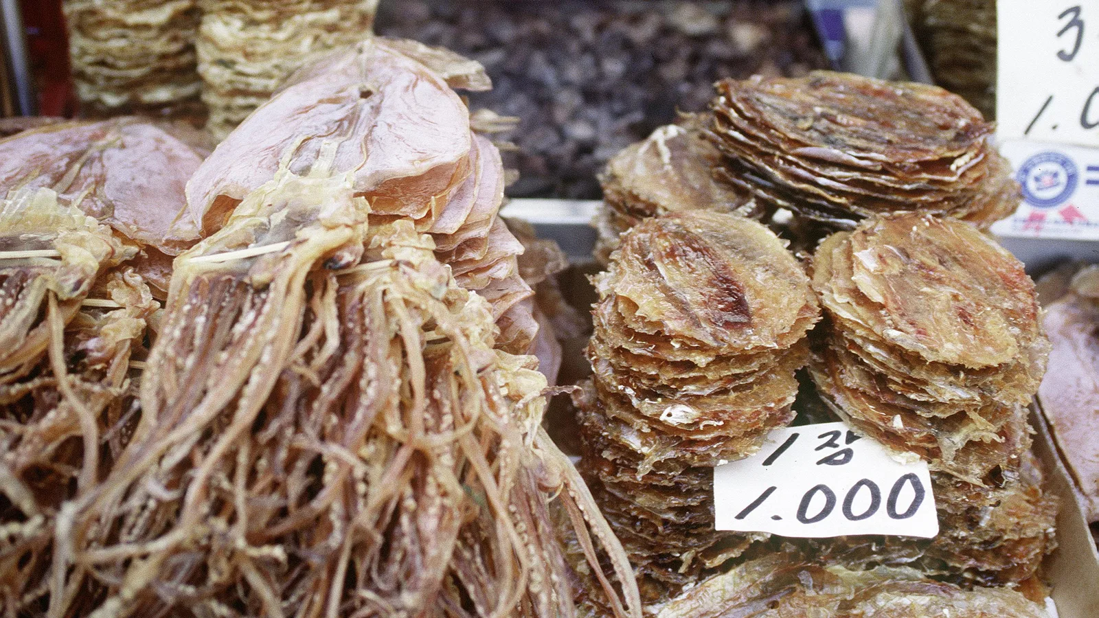 Dried seafood for sale at a stall in Namdaemun Market, Seoul, with a hand-written price tag.