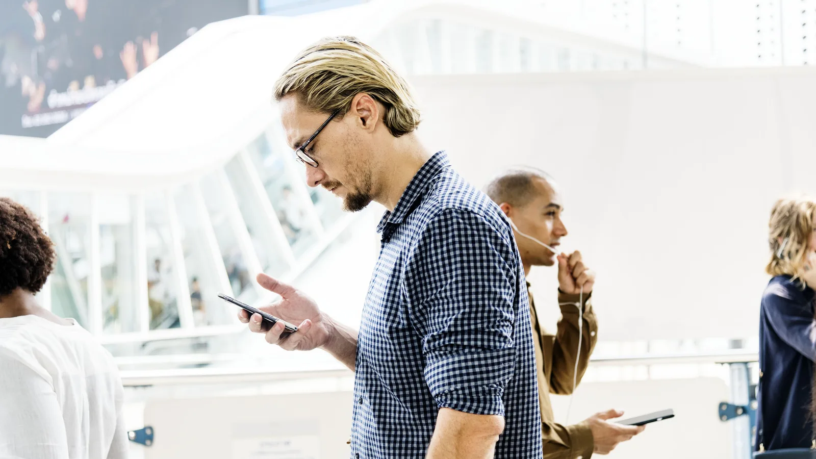 A man checking his phone while walking, representing looking up information about a show.