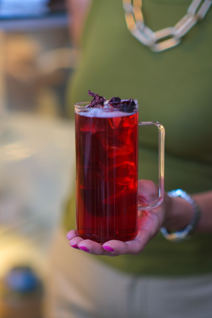A vibrant iced hibiscus tea served in a clear glass mug, captured in Ankara, Türkiye.