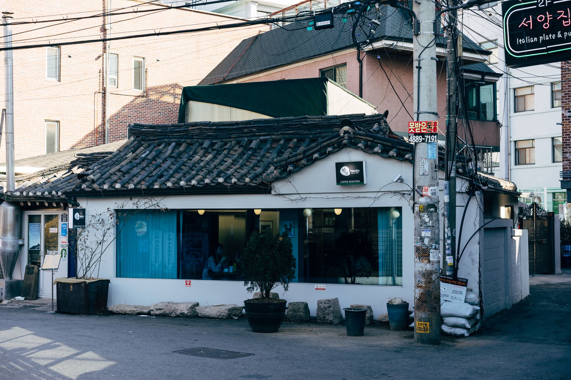 A charming traditional café with tiled roof in a Seoul street setting.