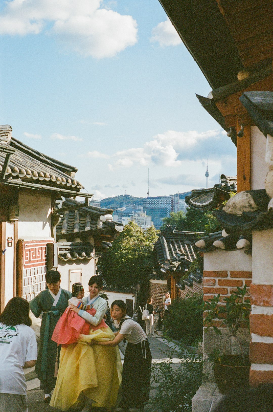 People in traditional korean hanbok walk through historic village
