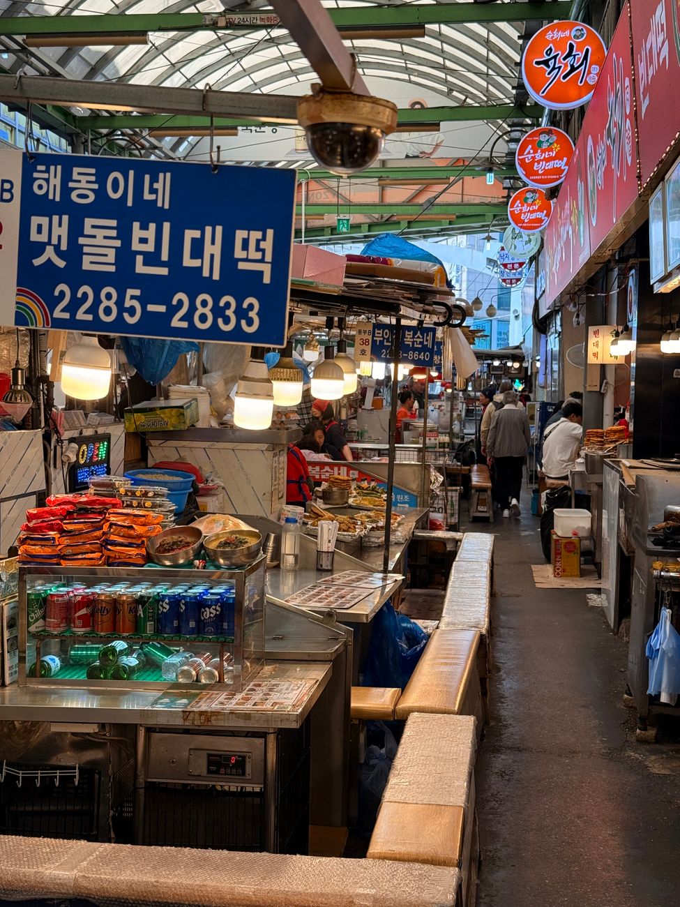 A bustling street market in Seoul featuring traditional Korean stalls and colorful signs.