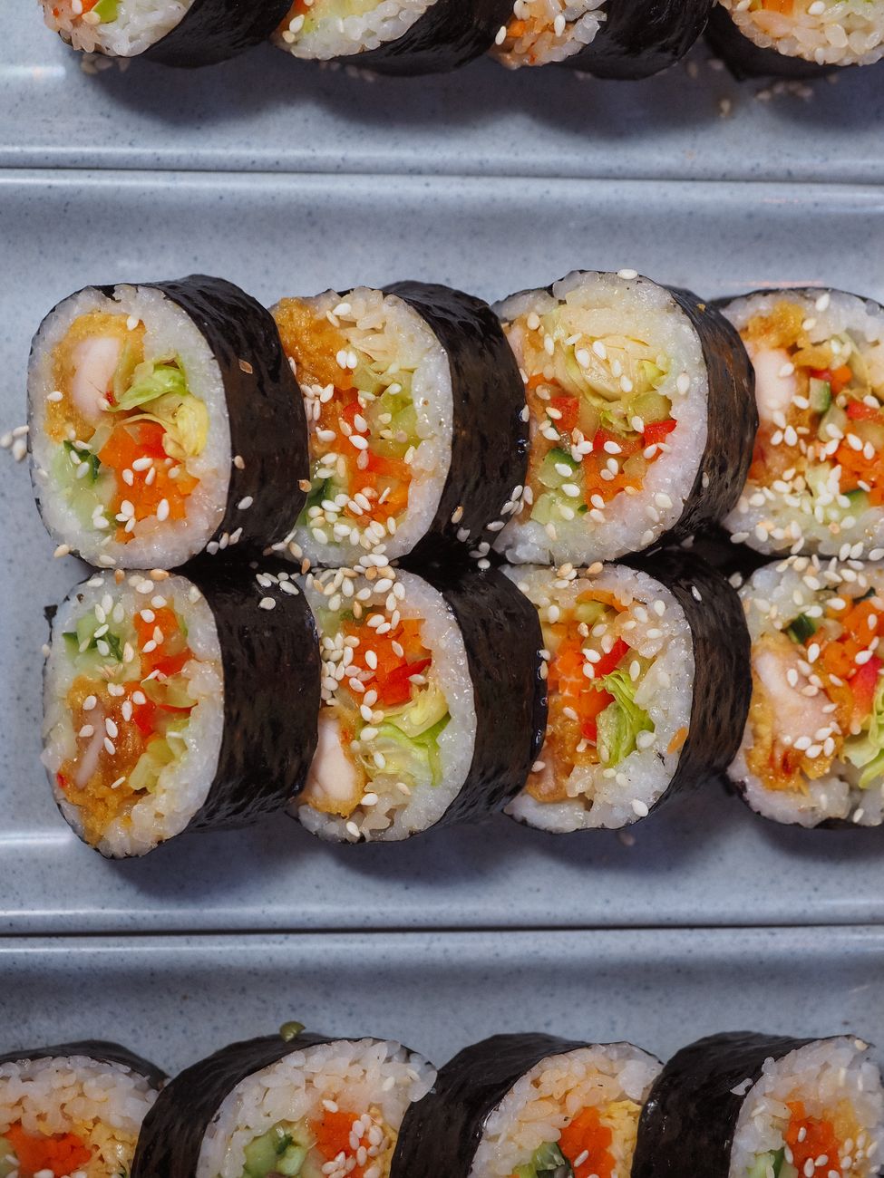Delicious gimbap rolls filled with vegetables and sesame seeds, top view.