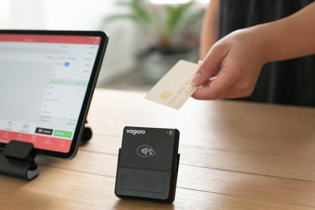 A person is making a transaction with a credit card on a Vagaro contactless card reader.