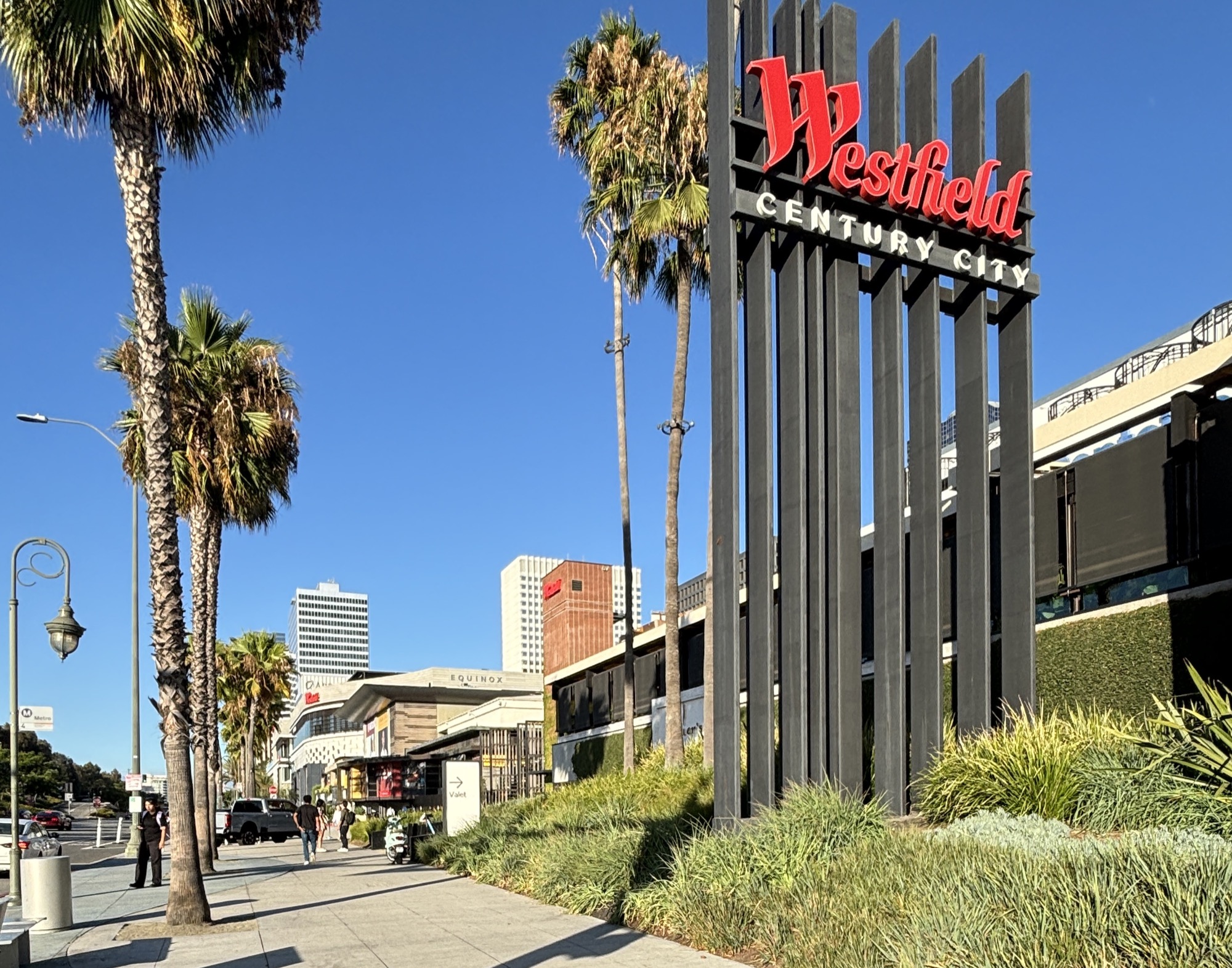 The Westfield Century City entrance sign in Los Angeles, California, palm trees in the foreground -- the mall that houses OLIVE YOUNG's second US store.