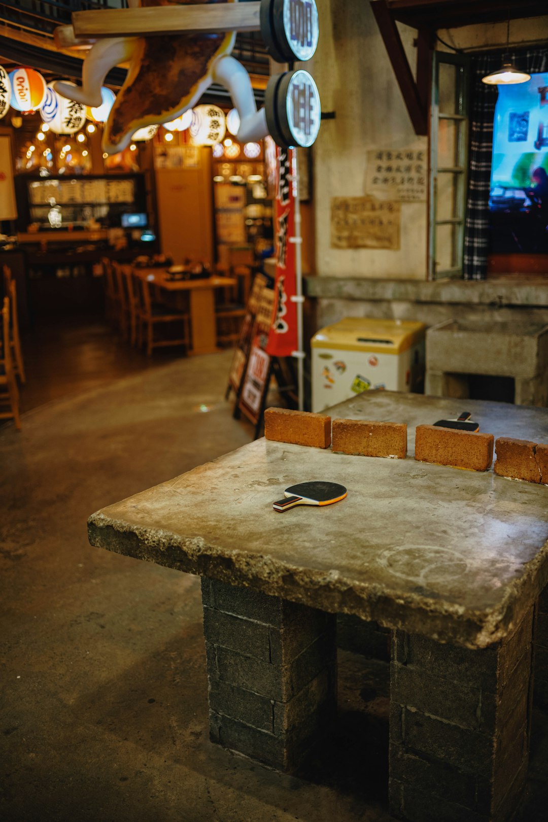 Ping pong table in a dimly lit restaurant setting.