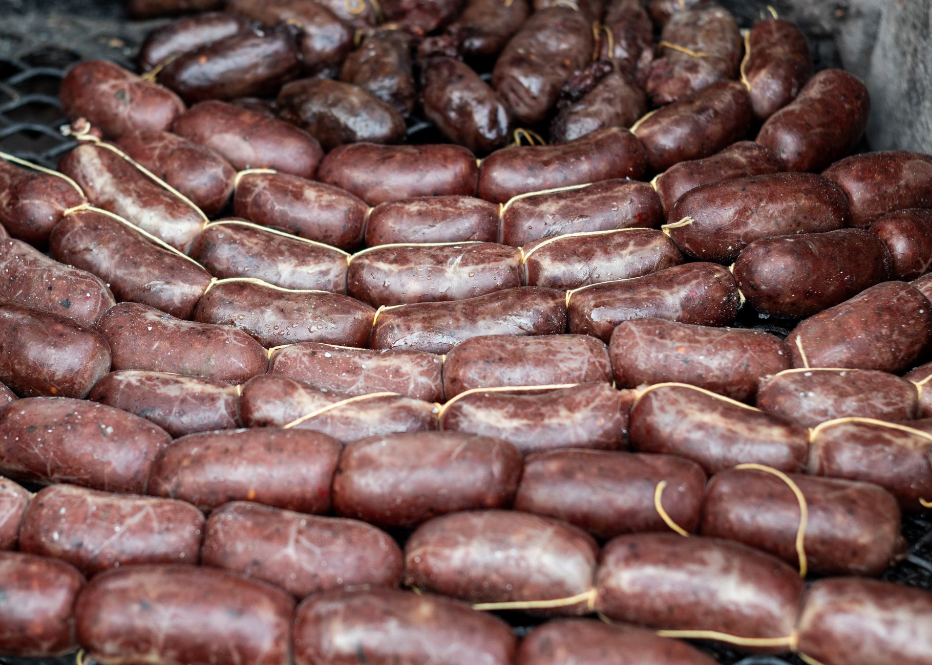 Authentic blood sausages sizzling on a parrilla in Uribelarrea, capturing the essence of Argentine cuisine.