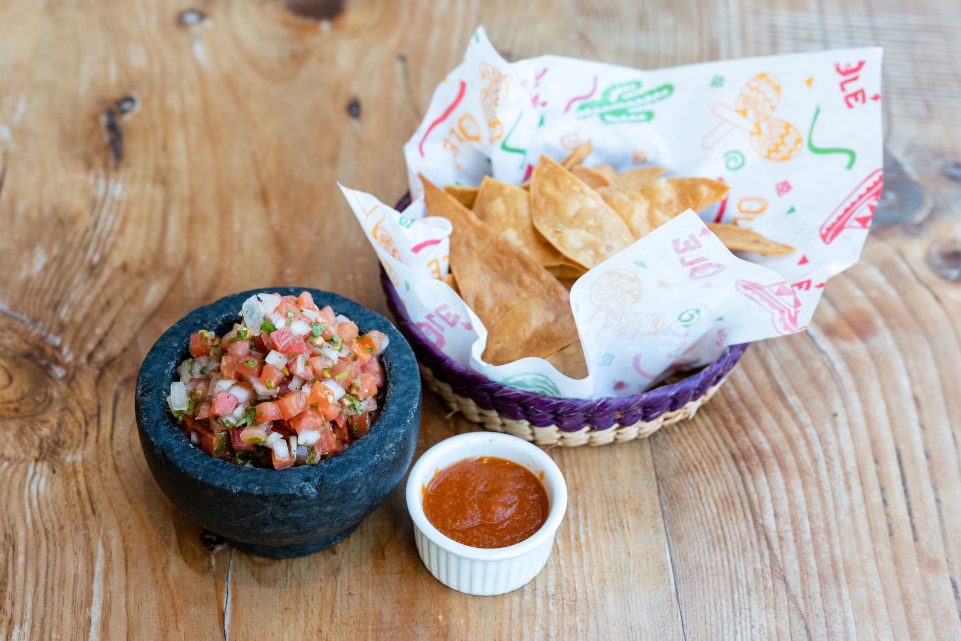 Rustic Mexican salsa and tortilla chips served on a wooden table, perfect for a traditional appetizer.
