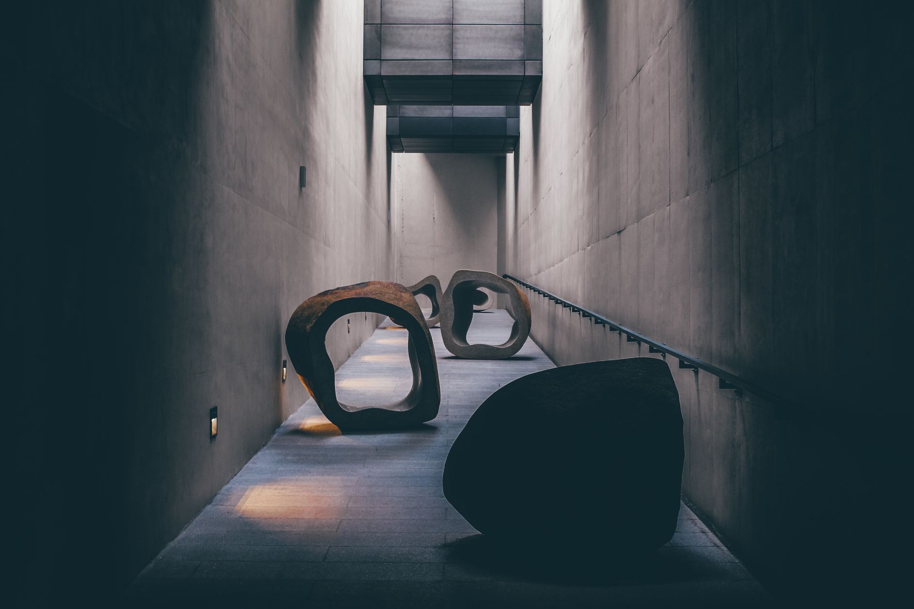 Explore a modern art sculpture installation in a dimly lit, minimalist corridor in Seoul.