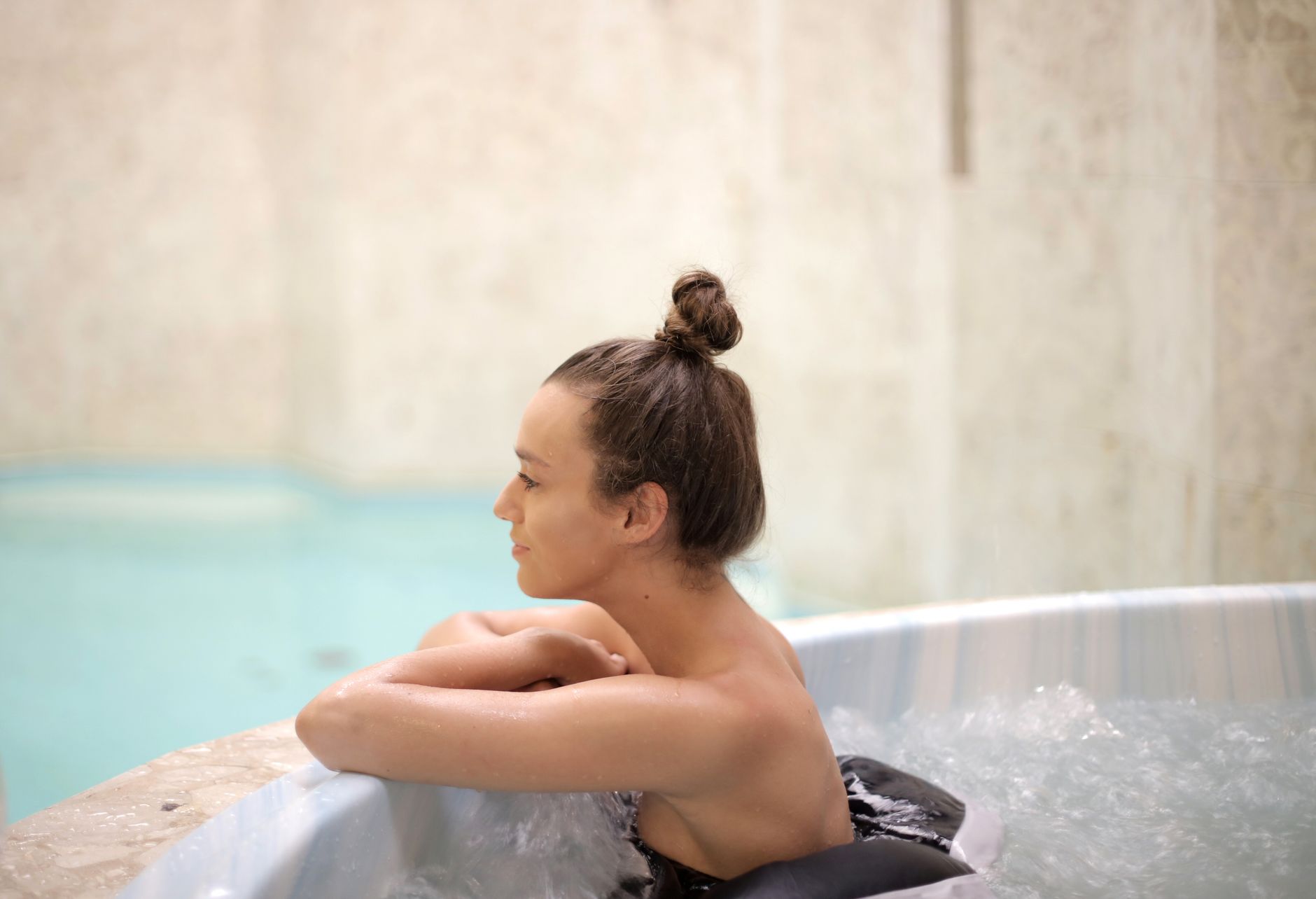 Woman enjoying a relaxing moment in an indoor hot tub, enhancing wellness and leisure.