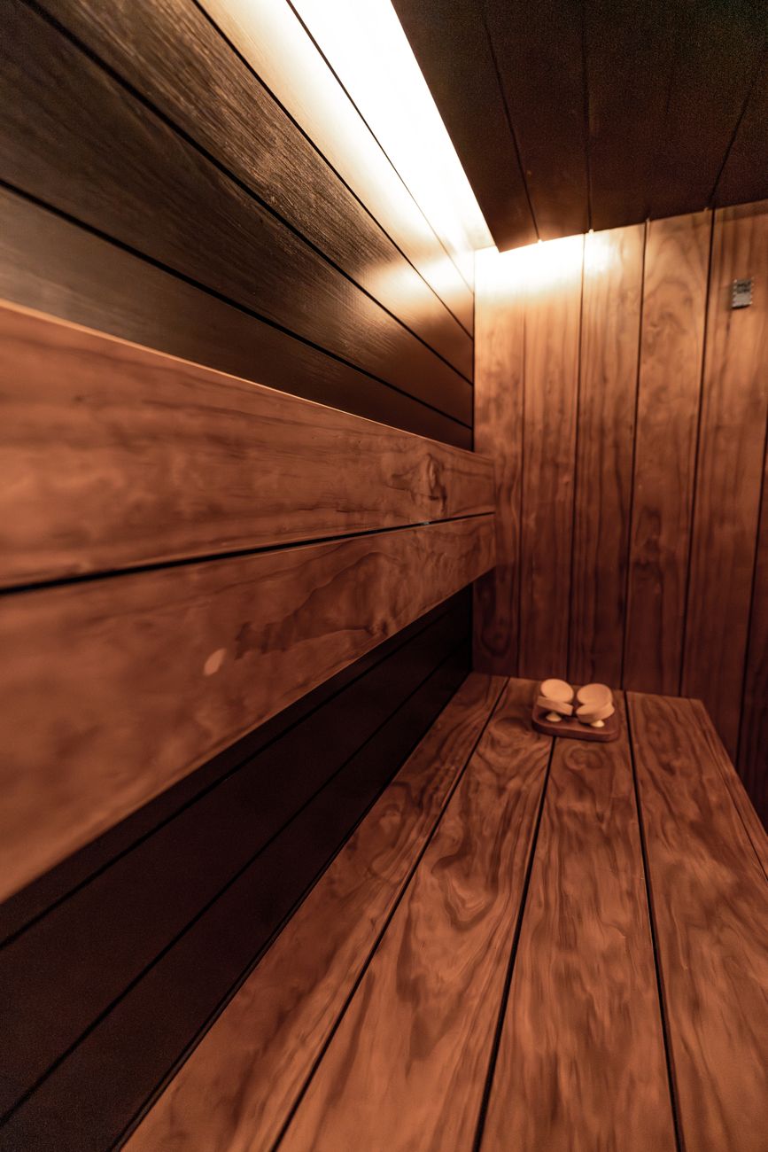 Luxurious indoor sauna with warm lighting, wooden benches, and modern design details.