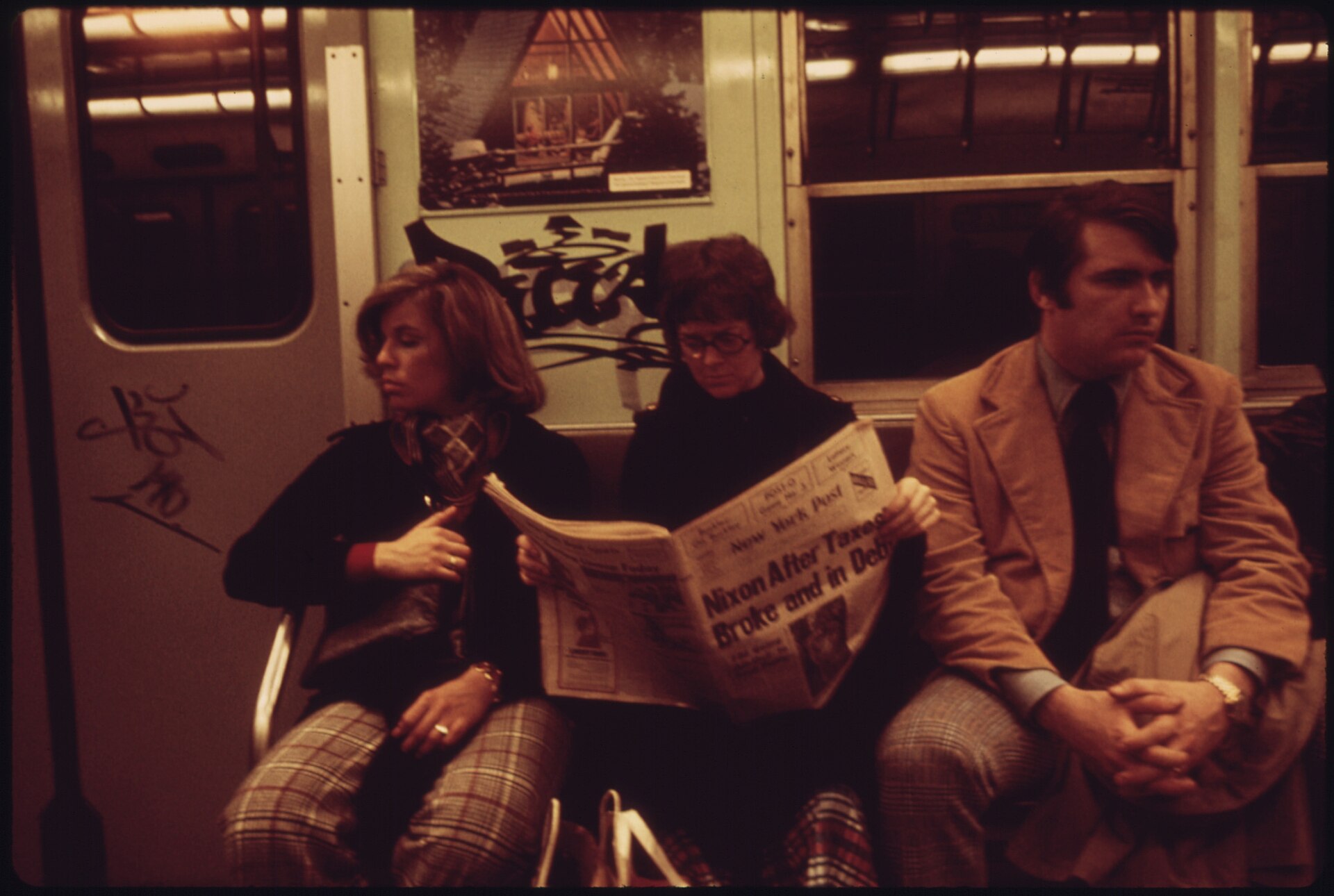 SUBWAY RIDERS LOST IN THEIR OWN THOUGHTS AND READING THE NEWSPAPER ON THE LEXINGTON AVENUE LINE OF THE NEW YORK CITY TRANSIT AUTHORITY.