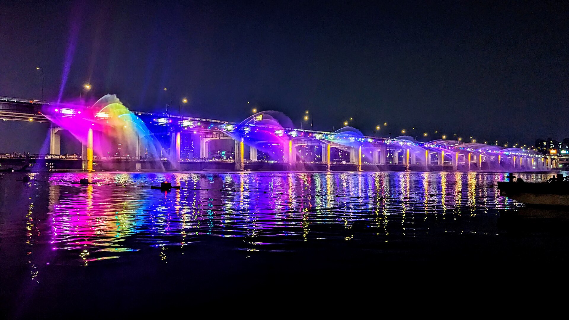 The Moonlight Rainbow Fountain on the Banpo Bridge in Seoul, South Korea, illuminated at night in rainbow colors.