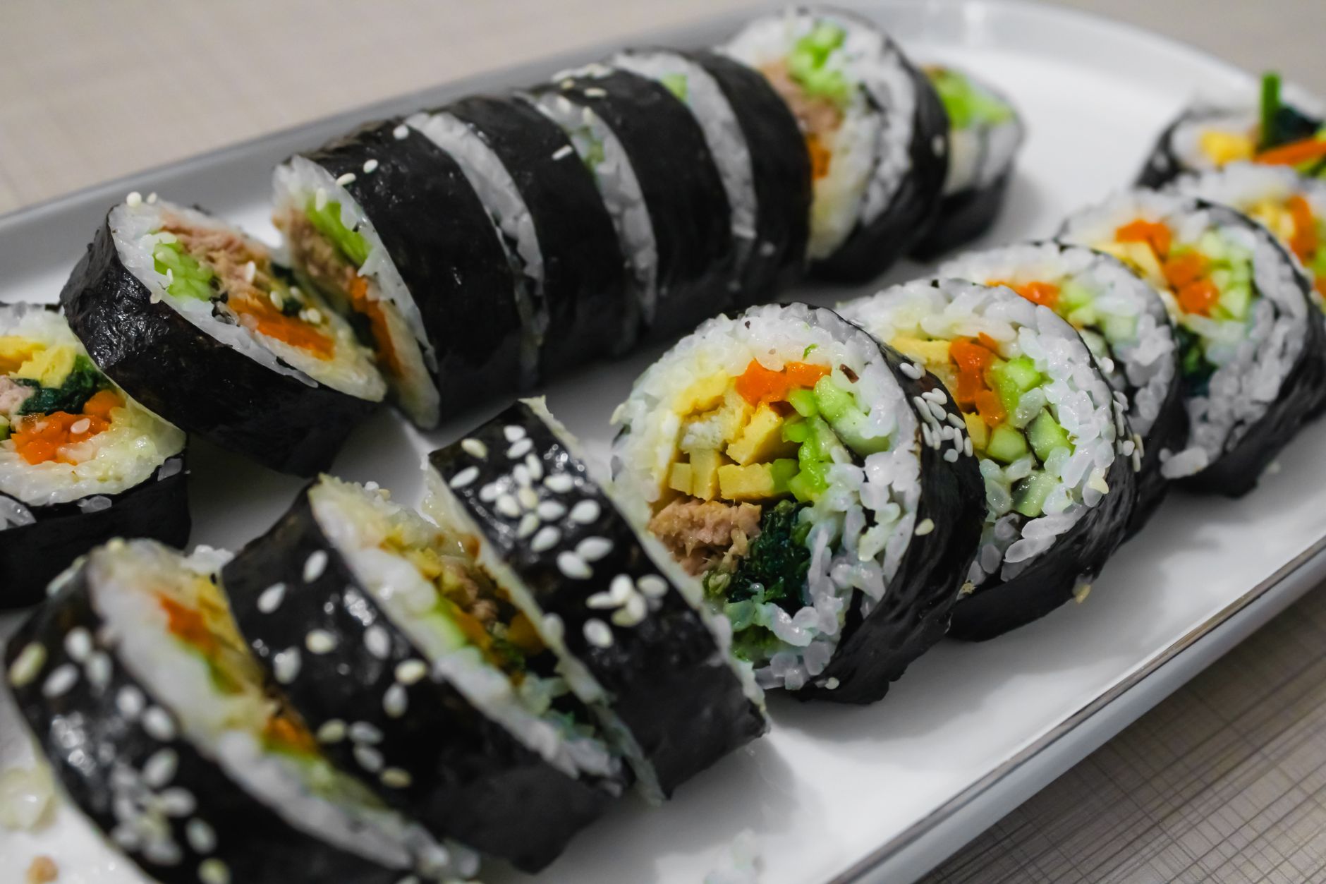 Close-up of freshly prepared Korean gimbap rolls with vibrant vegetables and rice.