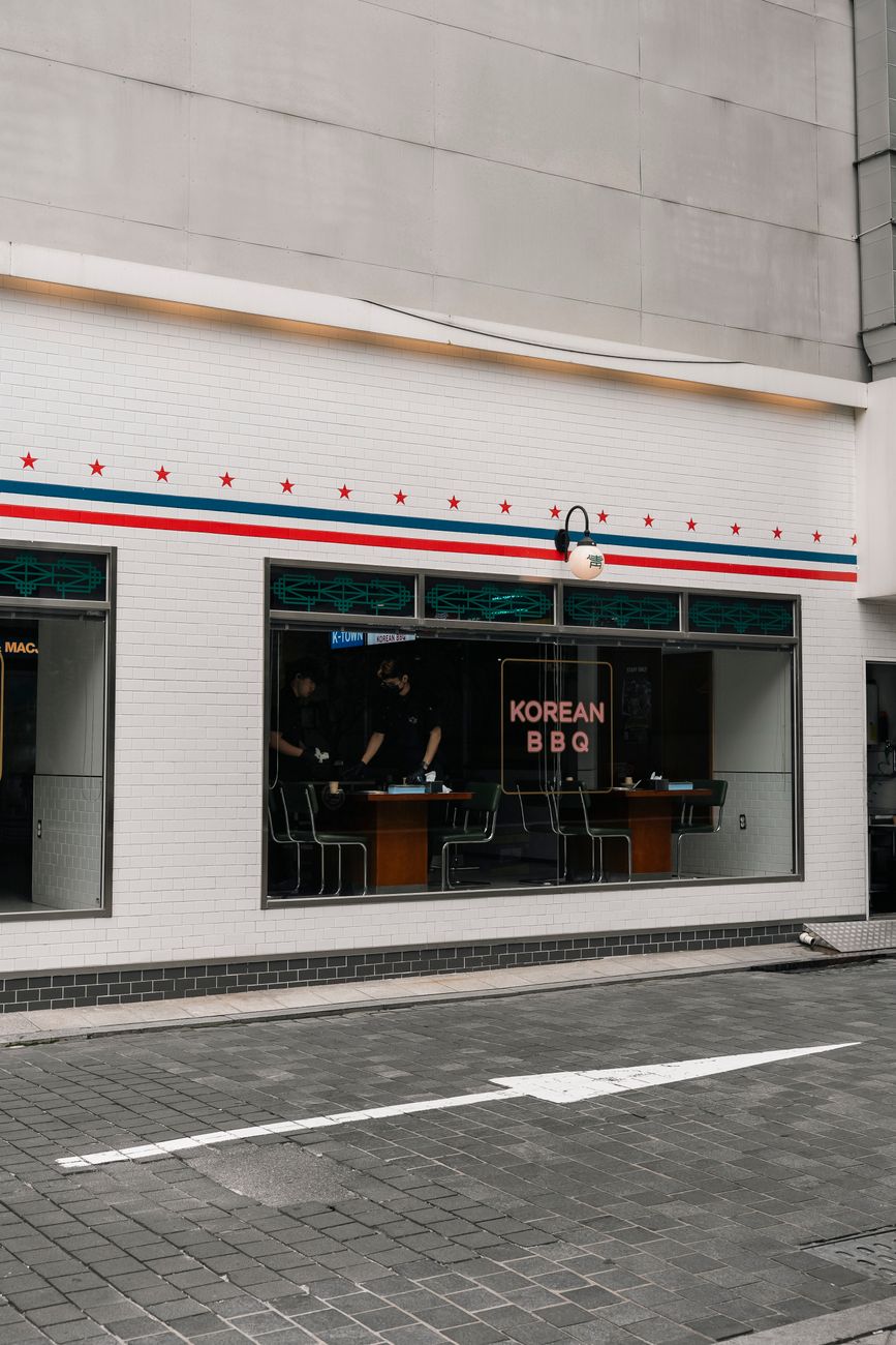 Exterior view of a Korean BBQ restaurant in Seoul with a modern white facade and colorful decor.