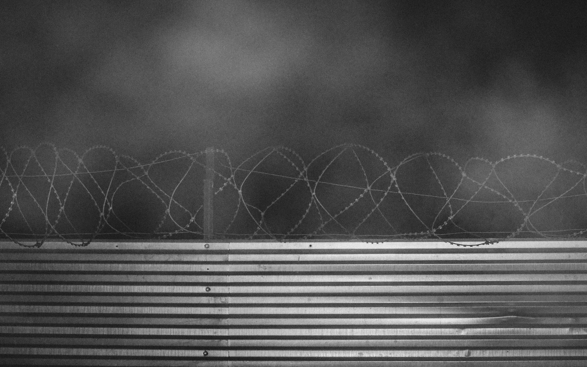 Grayscale photo of a barbed wire fence symbolizing security and protection in Moscow.