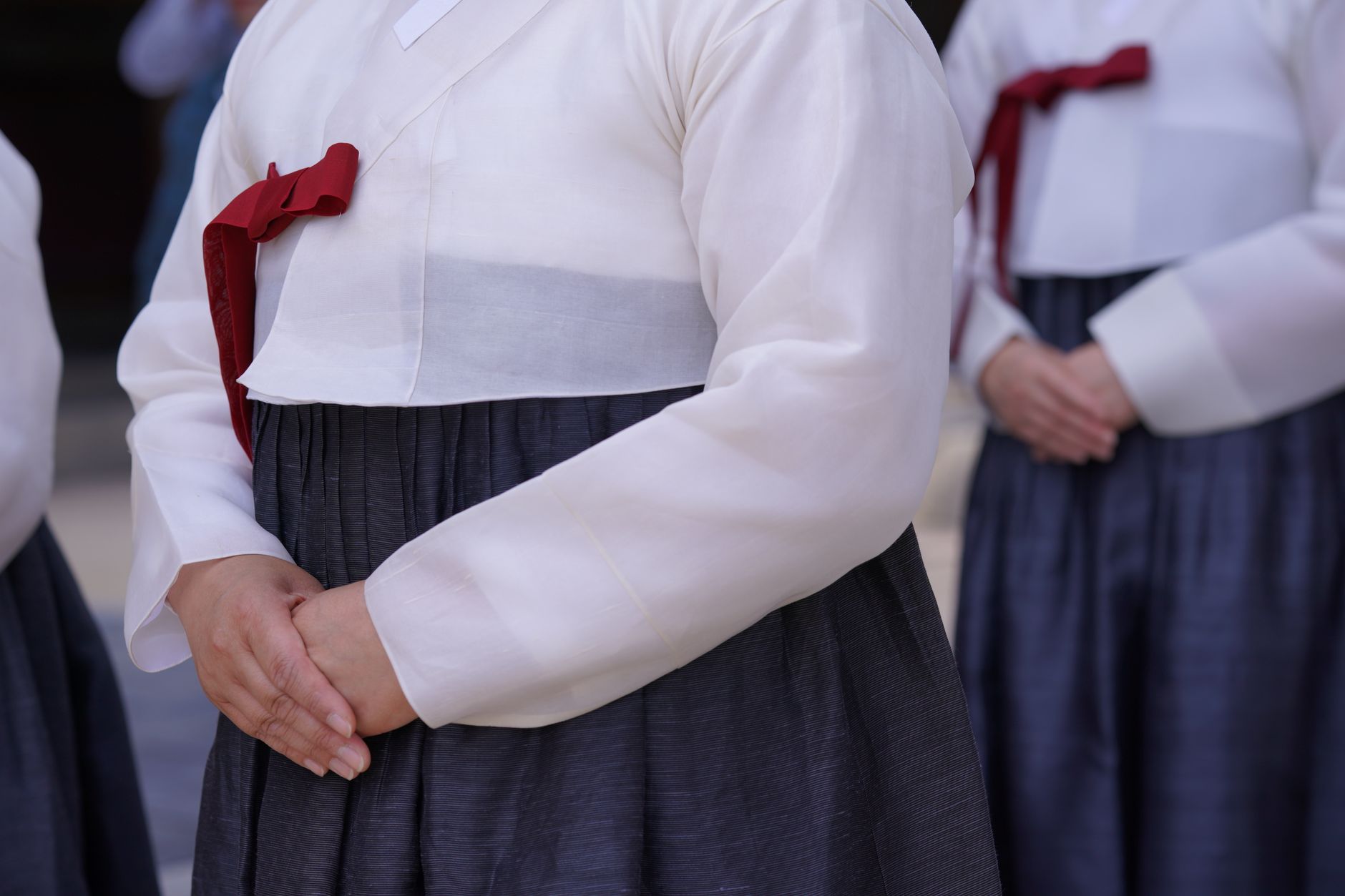 Close-up of women wearing traditional Korean hanboks during an outdoor ceremony, showcasing cultural attire.