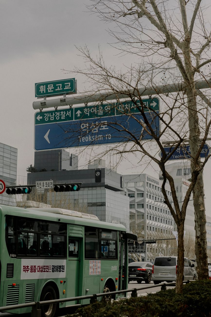 Busy urban street with buses and signs in Yeoksam-ro, Seoul, South Korea.