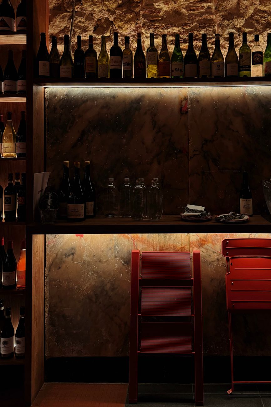 Inviting wine bar with an array of wine bottles and dim lighting for a warm ambiance.