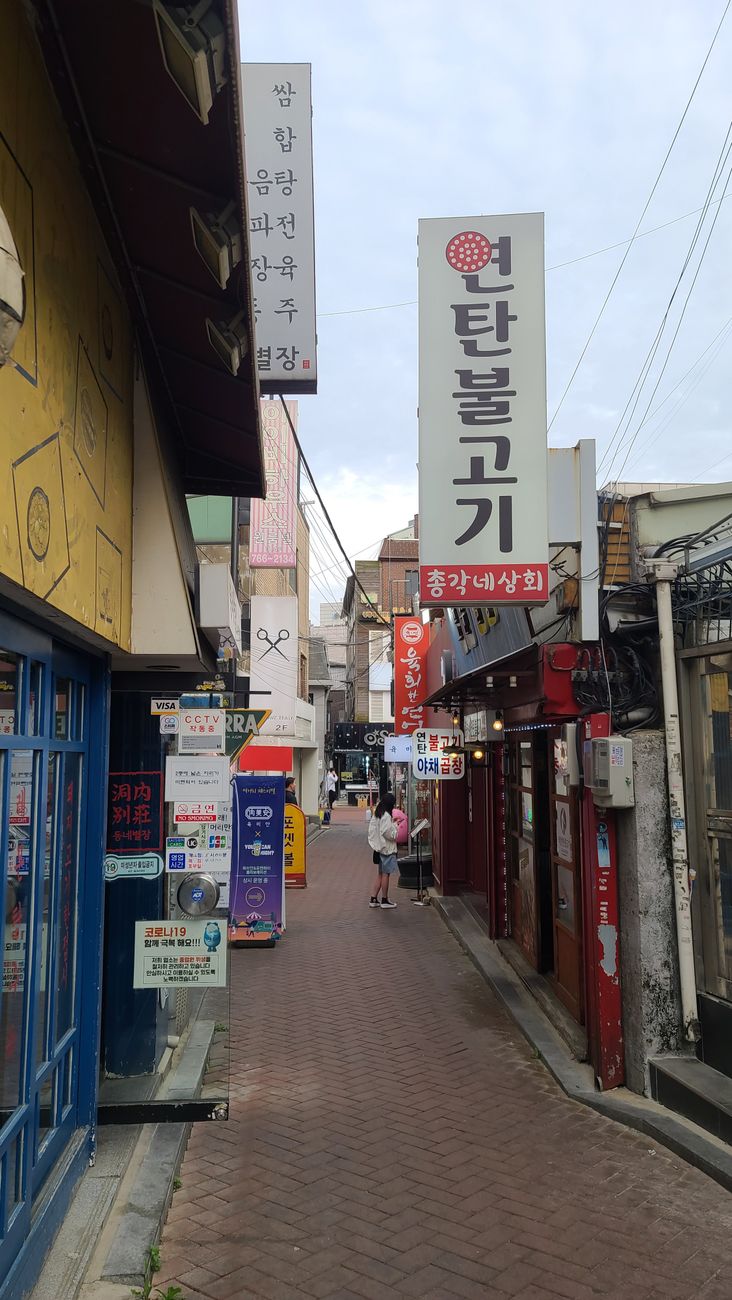Explore the vibrant alleyways of Seoul filled with local shops and colorful signages, capturing the essence of urban life.