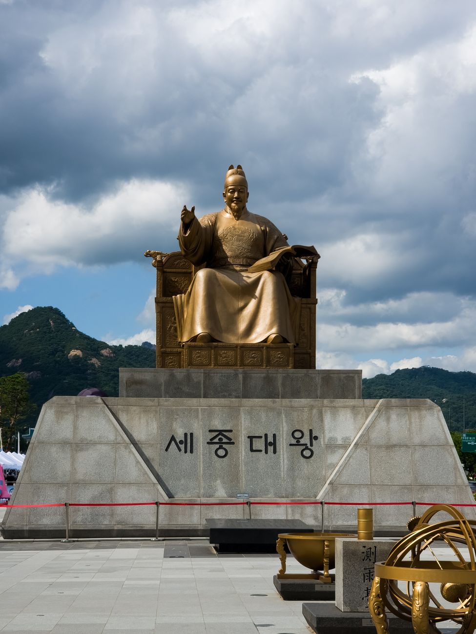 Statue of King Sejong in Seoul depicting the historical king against a cloudy sky.
