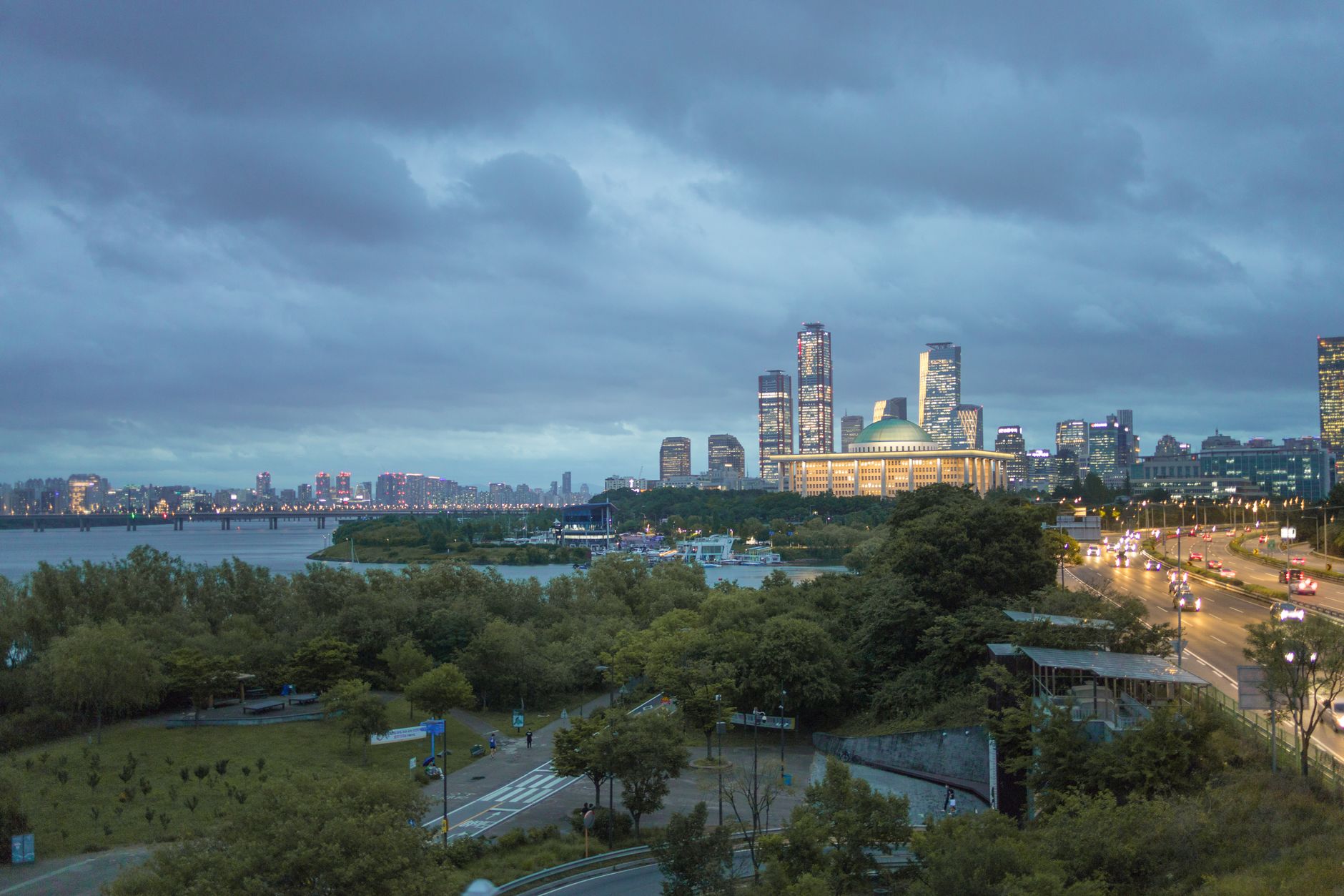 Dynamic view of Seoul's skyline featuring iconic structures and Han River at dusk.