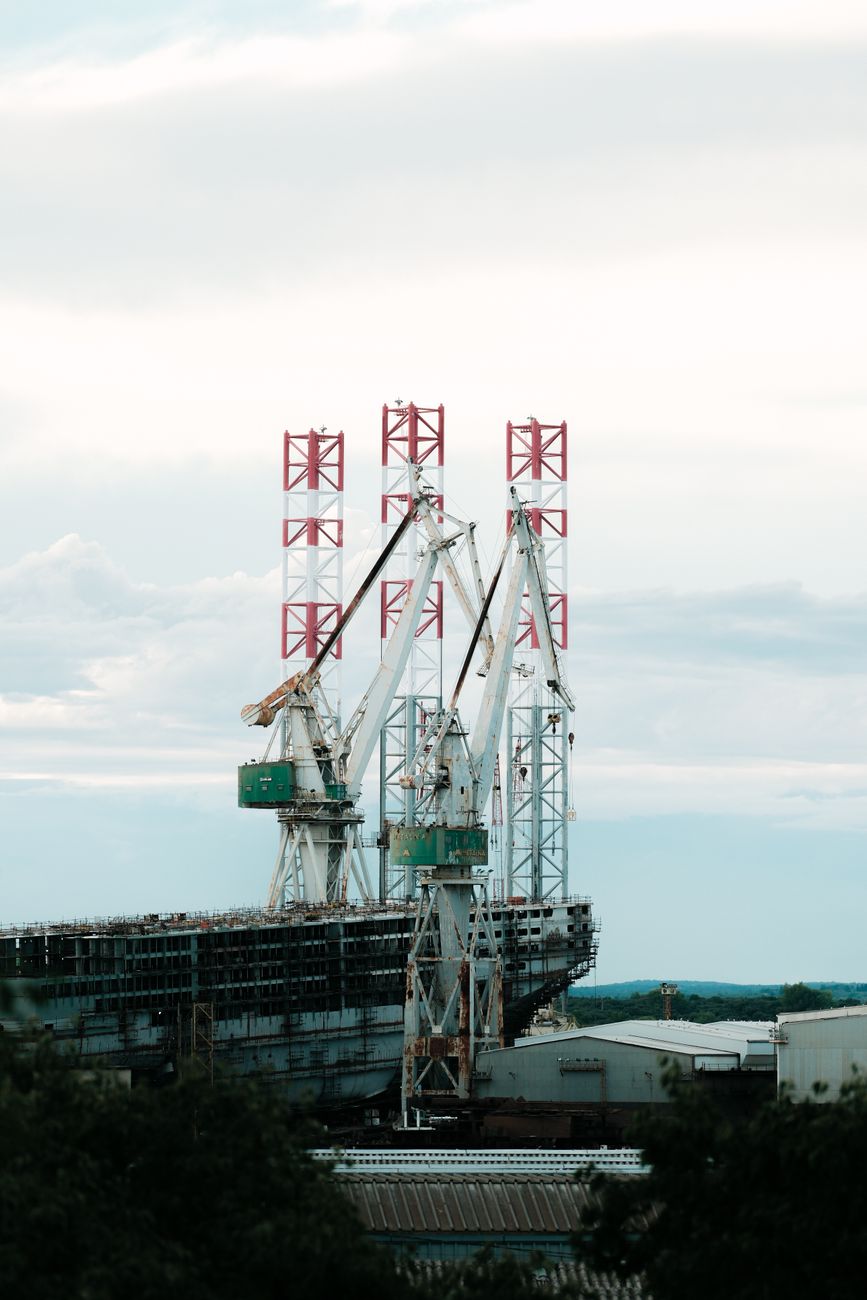 Cranes towering over a Croatian shipyard under a bright sky, showcasing industrial work.